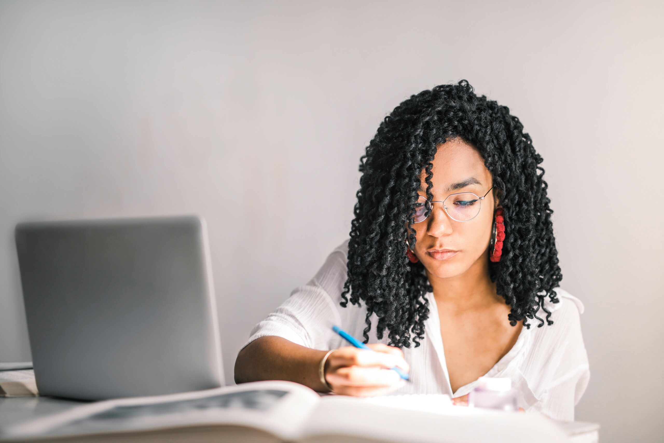 Female entrepreneur at laptop with notebook, representing the fight for creative business legitimacy and professional recognition