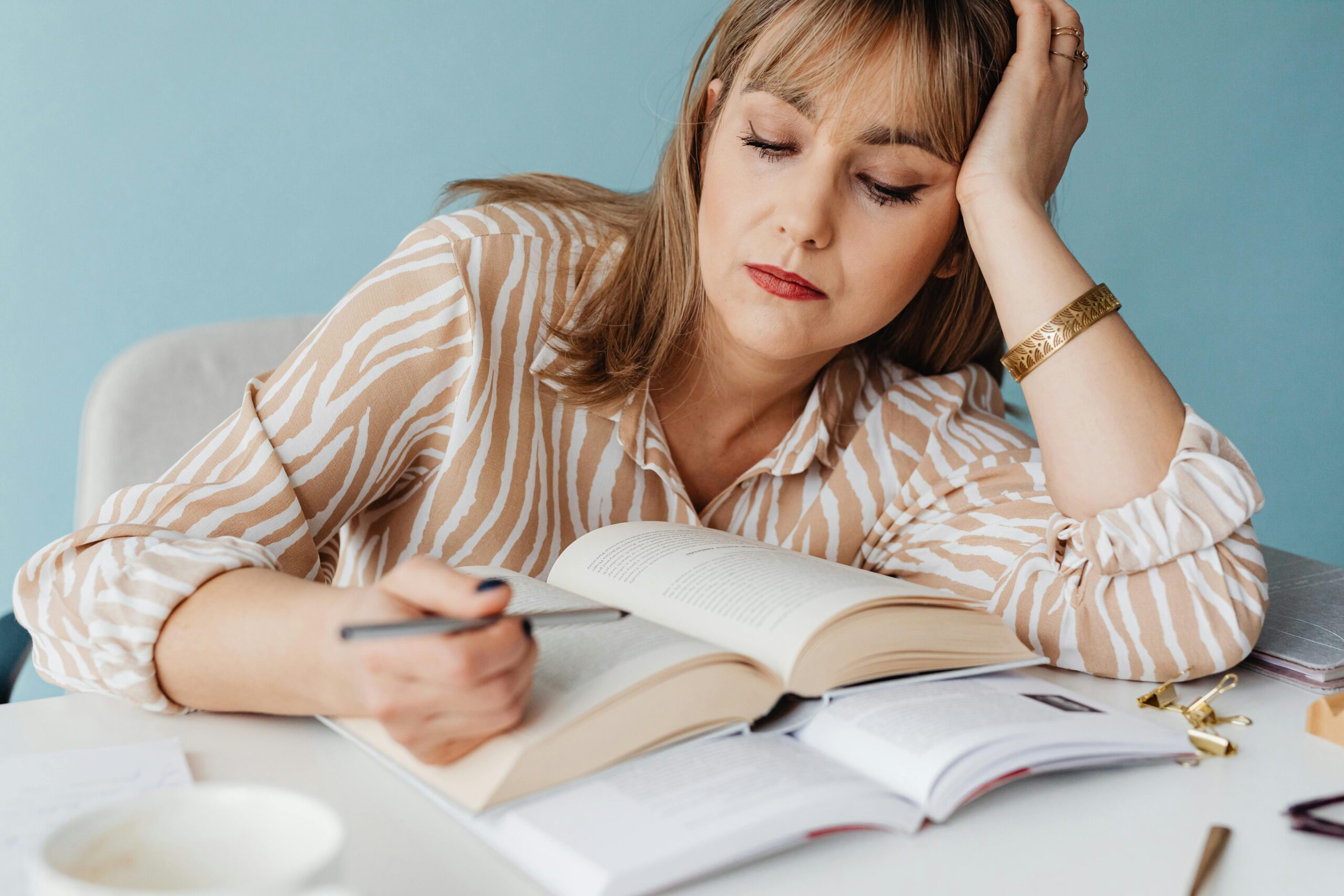 Creative business owner stuck in learning mode reading books instead of implementing business strategies